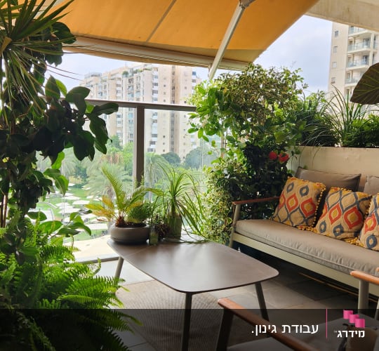 מרפסת עם צמחים ירוקים וריהוט גן